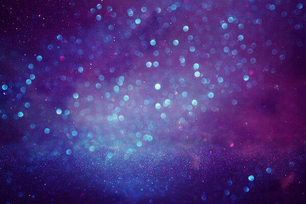 Glitter vintage lights background. purple, blue and pink. de focused