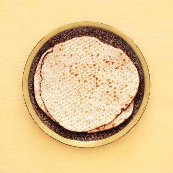 Passover background with matzoh over yellow wooden background. — Stock Photo, Image