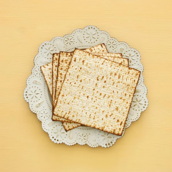 Passover background with matzoh over yellow wooden background. — Stock Photo, Image