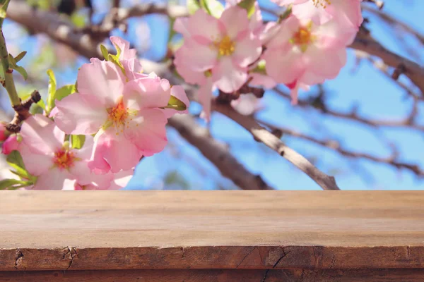 Деревянный деревенский стол перед весенним цветущим сакурой. демонстрация продукции и концепция пикника . — стоковое фото