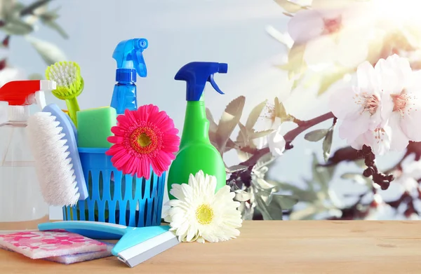 Spring cleaning concept with supplies on wooden table. — Stock Photo, Image