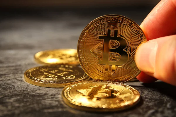 Hombre sosteniendo Bitcoin oro sobre fondo negro. Concepto empresarial . — Foto de Stock