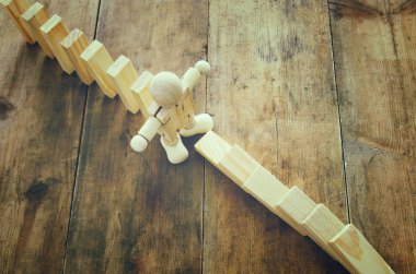 Domino etkisi durdurma tahta bir kukla. retro tarzı görüntü yürütme ve risk denetim kavramı.