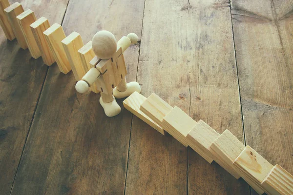 Un maniquí de madera deteniendo el efecto dominó. imagen de estilo retro ejecutivo y concepto de control de riesgos . — Foto de Stock