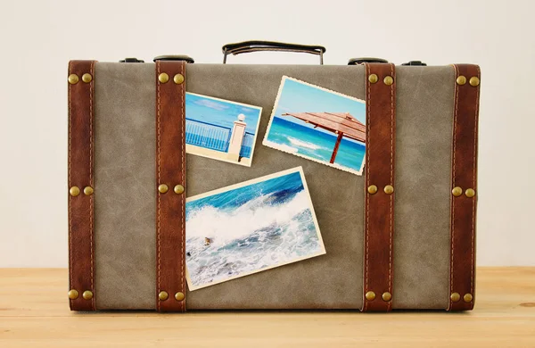 Wizerunek starego rocznika bagażu z zdjęcia z wakacji na drewnianej podłodze. — Zdjęcie stockowe