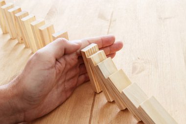 domino etkisi durdurma bir erkek eli. retro tarzı görüntü yürütme ve risk denetim kavramı.