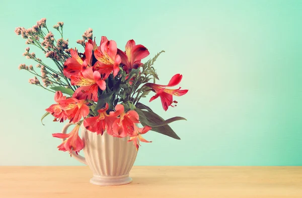 Nyári csokor piros virágok a vázában, fából készült asztal és háttér menta. — Stock Fotó