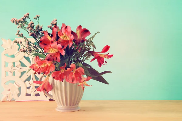 Bouquet d'été de fleurs rouges dans le vase sur table en bois et fond menthe . — Photo