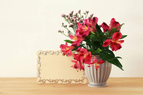 Sommerstrauß roter Blumen in der Vase über Holztisch und weißem Hintergrund. — Stockfoto