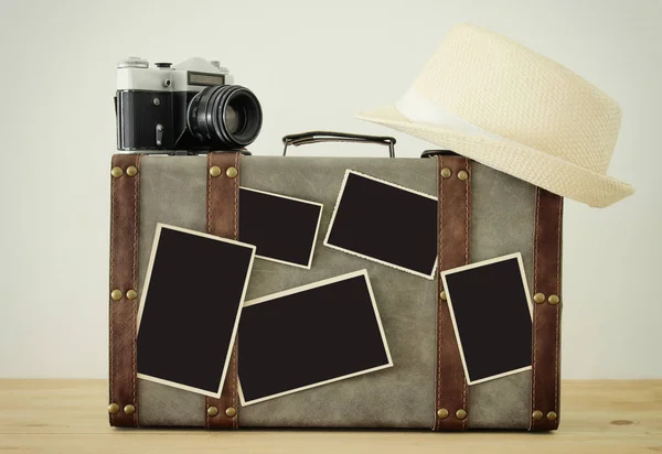 Image of old vintage luggage, fedora hat, vintage old photo camera and blank photos for photography montage mockup over wooden floor — Stock Photo, Image