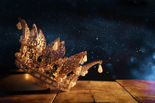Imagem chave baixa de bela rainha / rei coroa no livro antigo. período medieval fantasia. Foco seletivo . — Fotografia de Stock