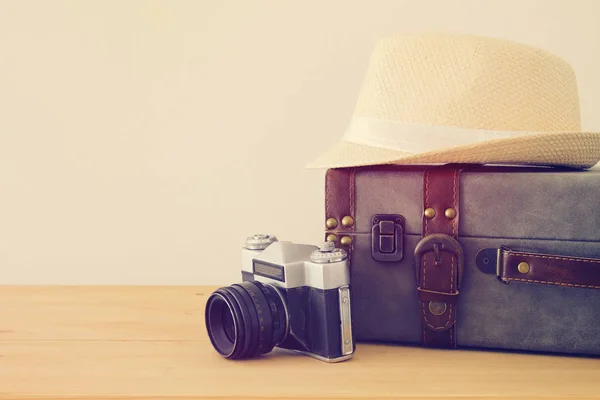 Equipaje vintage viajero, cámara y sombrero fedora sobre mesa de madera. vacaciones y concepto de vacaciones . —  Fotos de Stock