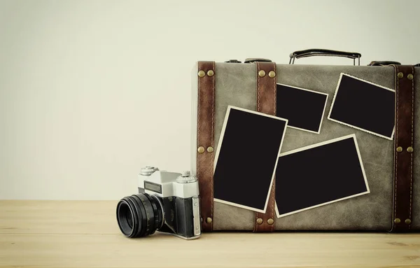 Foto van oude vintage Reiskoffers, vintage oude fotocamera en leeg foto's montage mockup van fotografie over houten vloer. — Stockfoto