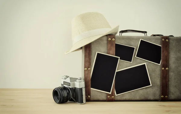 Imagem de bagagem vintage velha, chapéu fedora, câmera de foto antiga vintage e fotos em branco para montagem de fotografia mockup sobre piso de madeira . — Fotografia de Stock