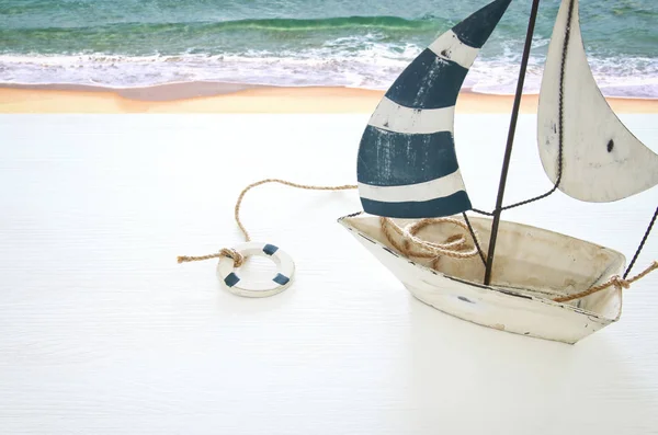 Concetto nautico con barca a vela decorativa bianca su tavolo di legno bianco . — Foto Stock