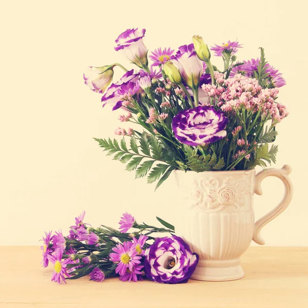 Buquê de verão de flores roxas no vaso sobre mesa de madeira e fundo branco . — Fotografia de Stock