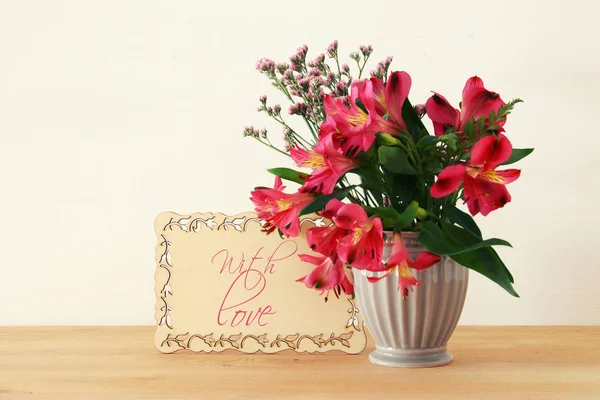 Bouquet d'été de fleurs rouges dans le vase sur table en bois et fond blanc . — Photo