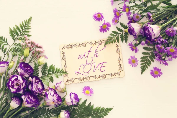 Vue du dessus de violette belle disposition des fleurs sur fond blanc en bois . — Photo