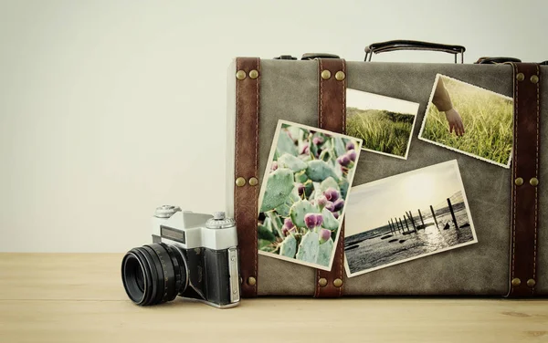 Imagem de bagagem vintage velha, chapéu fedora e câmera de foto antiga vintage com fotos da natureza sobre piso de madeira . — Fotografia de Stock