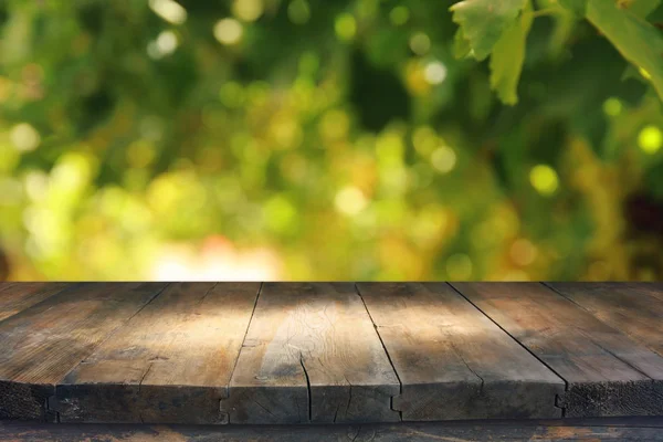 Leerer rustikaler Tisch vor grünem Frühling abstrakten Bokeh-Hintergrund. Produktpräsentation und Picknickkonzept. — Stockfoto