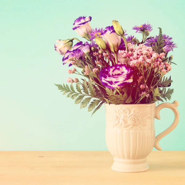 Bouquet d'été de fleurs violettes dans le vase sur table en bois et fond menthe . — Photo