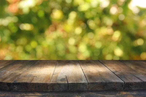 Пустой деревенский стол на зеленом весеннем абстрактном боке. демонстрация продукции и концепция пикника . — стоковое фото