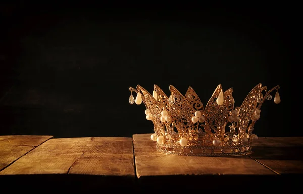 Imagem chave baixa de bela rainha / rei coroa sobre mesa de madeira. vintage filtrado. período medieval fantasia. — Fotografia de Stock