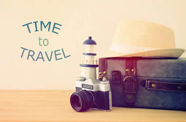 Viajante bagagem vintage, câmera e chapéu fedora sobre mesa de madeira. conceito de férias e férias . — Fotografia de Stock