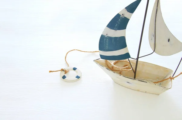 Conceito náutico com barco de vela decorativo branco sobre mesa de madeira branca . — Fotografia de Stock