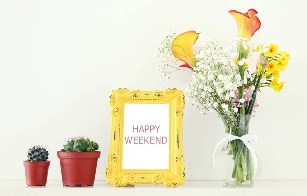 Imagem de belo buquê de flores amarelas da primavera ao lado de moldura de foto vintage sobre mesa branca . — Fotografia de Stock