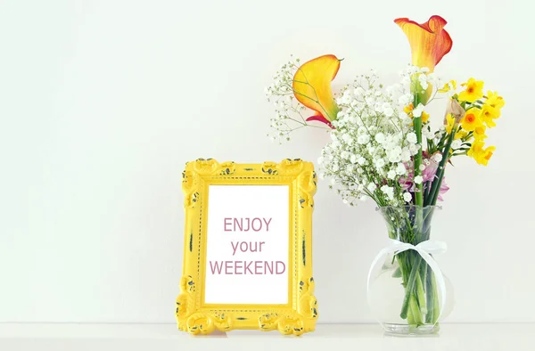Imagen de hermoso ramo de flores amarillas de primavera junto al marco de fotos vintage sobre mesa blanca . — Foto de Stock