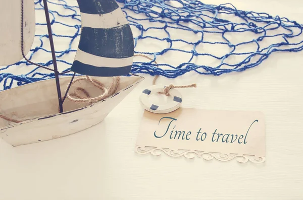 Морское концептуальное изображение с белой декоративной парусной лодкой с заметкой над белым деревянным столом . — стоковое фото
