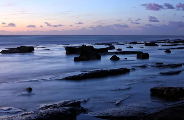 Hintergrund von Strand und Meer bei Sonnenuntergang Farben. — Stockfoto