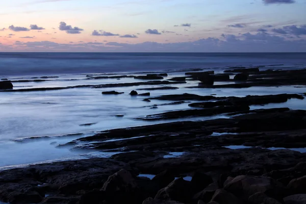 Hintergrund von Strand und Meer bei Sonnenuntergang Farben. — Stockfoto