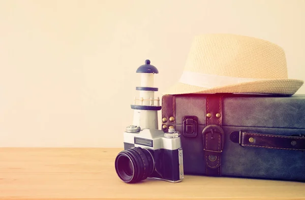 Traveler vintage luggage, camera and fedora hat over wooden table. holiday and vacation concept. — Stock Photo, Image