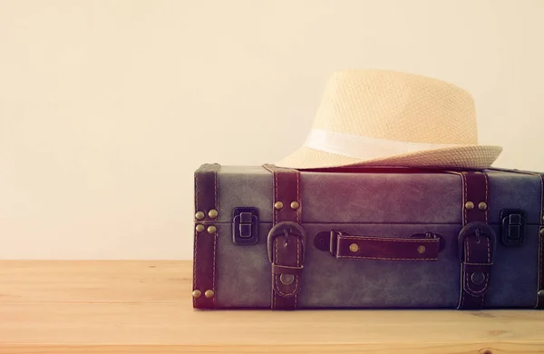 Equipaje vintage viajero, cámara y sombrero fedora sobre mesa de madera. vacaciones y concepto de vacaciones . — Foto de Stock