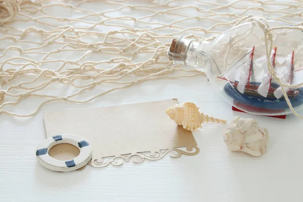 瓶と白い木製テーブルの上空メモ帆船で航海のコンセプト イメージ. — ストック写真