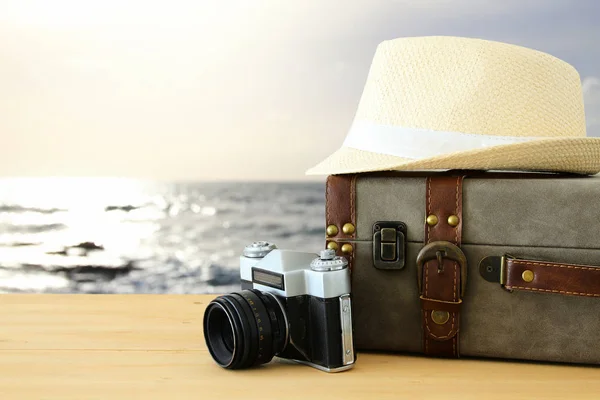 Reiziger vintage bagage, camera en fedora hoed over houten tabl — Stockfoto