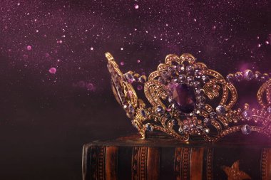 Tahta masanın üzerindeki güzel kraliçe ve kral tacının gösterişsiz görüntüsü. Eski model filtrelenmiş. fantezi ortaçağ dönemi.