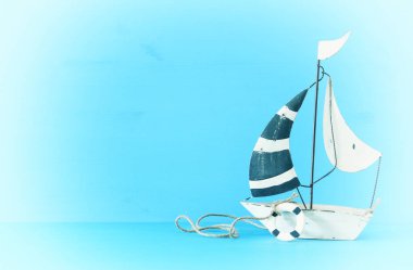 Beyaz dekoratif yelken ile deniz kavramı mavi ahşap masa üzerinde tekne. Vintage filtre uygulanmış görüntü.