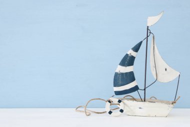 Beyaz ahşap masa üzerinde yelken teknesi ile deniz kavramı