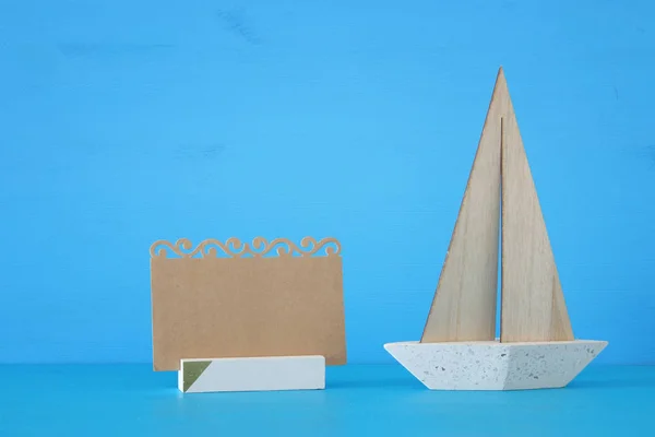 Yelkenli tekne ve mavi ahşap masa ve arka plan üzerinde boş Not ile deniz kavramı görüntü. — Stok fotoğraf