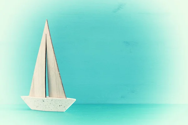 Mavi ahşap masa ve arka plan üzerinde beyaz dekoratif yelkenli tekne ile deniz kavramı. — Stok fotoğraf