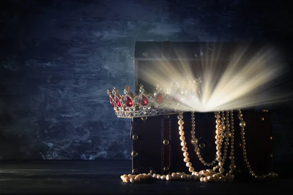 Изображение таинственного открытого деревянного сундука со светлой короной королевы / короля с красными камнями из рубинов. Средневековый период фантазий. Селективный фокус — стоковое фото