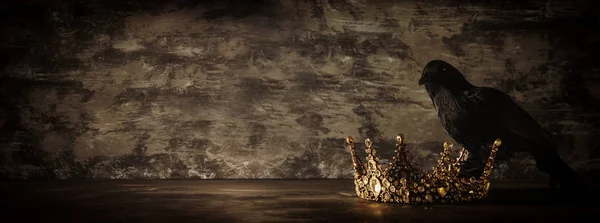 Imagen de la llave baja de la hermosa corona reina / rey y cuervo negro. época medieval de fantasía. Enfoque selectivo . — Foto de Stock