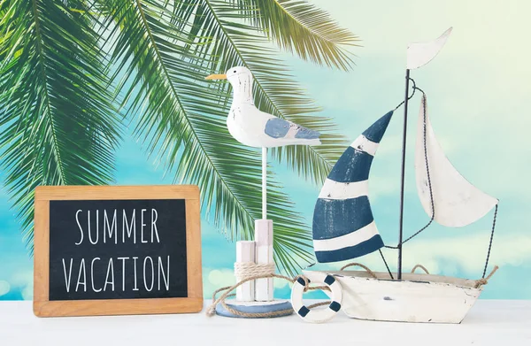 Nautical concept with white decorative seagull bird, blackboard and boat over tropical sea landscape background. — Stock Photo, Image