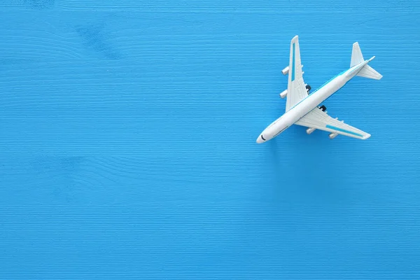 Foto vista superior do avião de brinquedo sobre fundo de madeira azul . — Fotografia de Stock