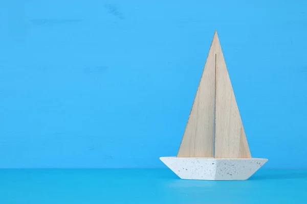 Conceito náutico com barco de vela decorativo branco sobre mesa de madeira azul e fundo . — Fotografia de Stock