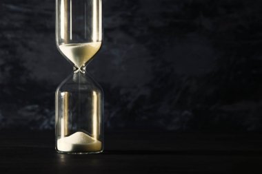 İş son tarih için siyah arka plan üzerinde zaman geçen kavram olarak kum saati görüntüsü.