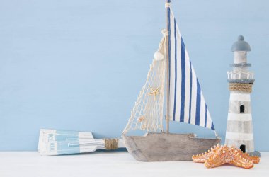 Beyaz dekoratif fener, ahşap kürek ve tekne üzerinde mavi arka plan ile deniz kavramı.